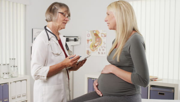 doctor explaining instructions to sitting pregnant woman