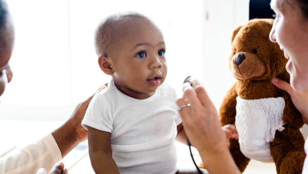 a newborn with a teddy bear wearing a diaper