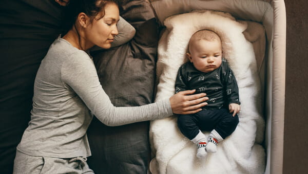 a woman laying next to her newborn child in bed