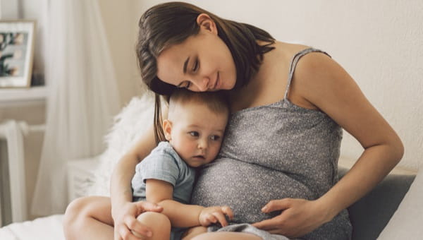 a young pregnant mother with her baby boy