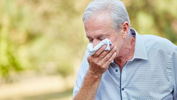 A man coughing into a handkerchief