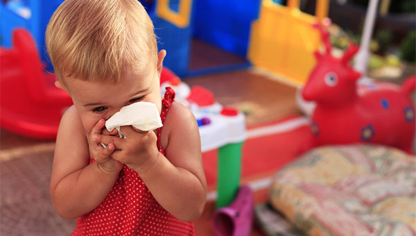 A toddler blowing their nose