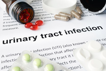 Medication is placed on top of a Urinary Tract Infection fact sheet