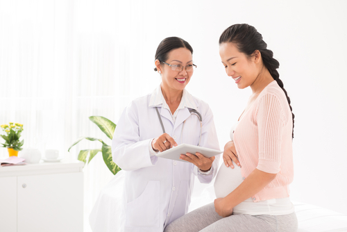 A pregnant woman talks with her doctor.