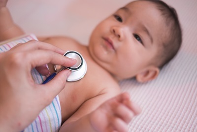 A doctor listens to a baby's heartbeat during an office visit.