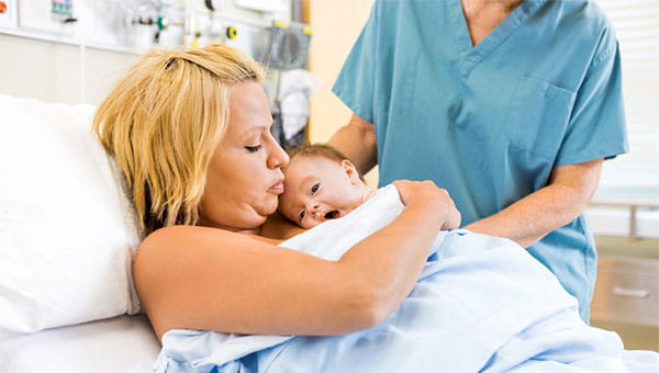 A mom holds her newborn baby after giving birth