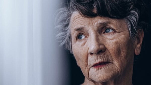 Mature lady sadly looking out of a window