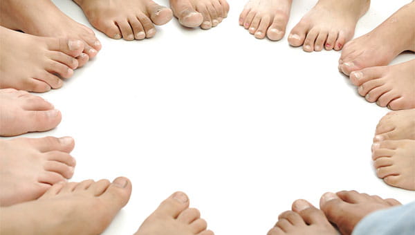 Several people are barefoot and sitting in a circle.