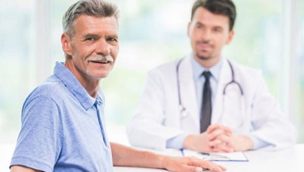 An older man talks with his primary care physician