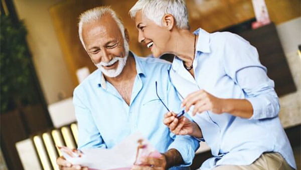 Older man and woman smiling at each other