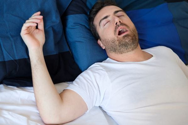 man laying in bed, snoring