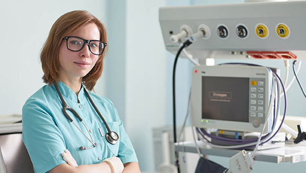 female nurse in front of a hospital machine