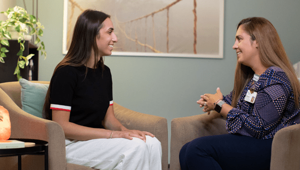 Two females engaging in a conversation about behavioral health.