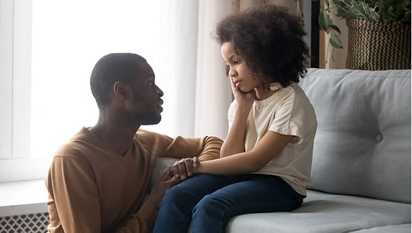 father speaking to young daughter