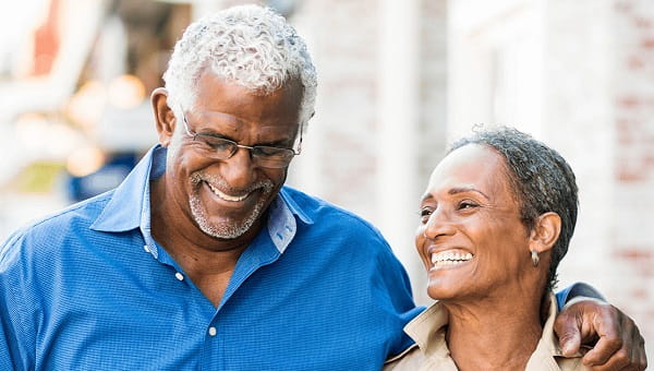 A senior couple is walking together outdoors.