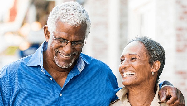 A senior couple is walking together outdoors.