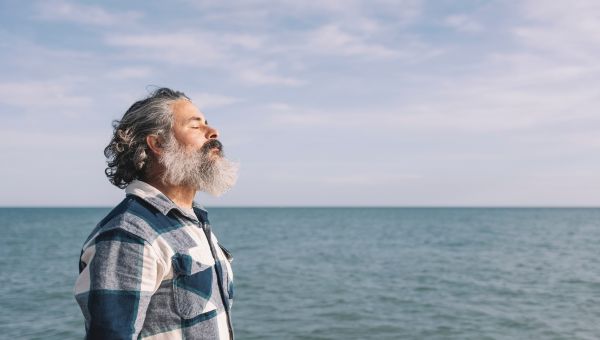 Man taking a deep breath by the ocean