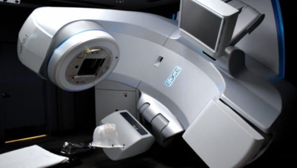 A linear accelerator medical machine is displayed in a dimly lit room, emphasizing its advanced technology.