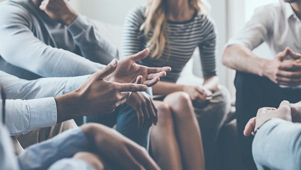 A group of men and women are at a speech therapy meeting.