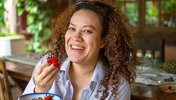 A woman happily eating strawberries