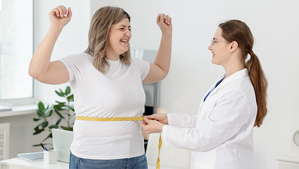 A patient celebrating weight loss with their provider