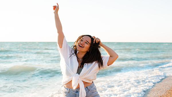 A woman stretching happily on the beach