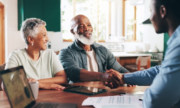 An older couple shakes hands with a man during a BayCare Medicare Advantage personal consultation.