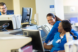 Smiling medical staff working in front of a computer
