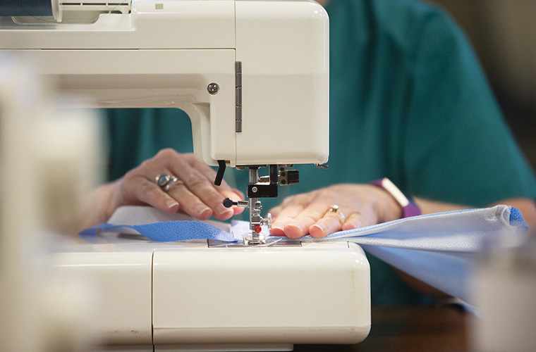 Person at a sewing machine making a mask