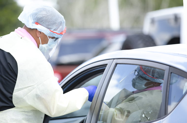Medical professional administering nasal swab at testing center