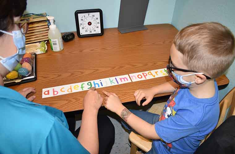 Lisa O’Hanlan, speech language pathologist, points at words as Allen Walker, 6, practices saying them.