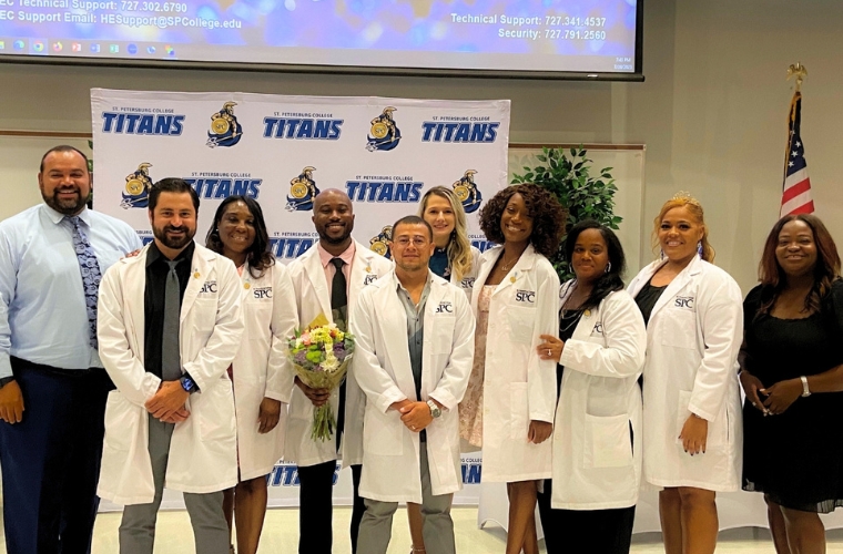 Photo of 8 surgical technologists at their graduation standing by two support staff.
