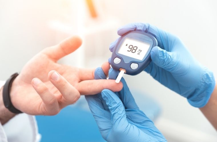 A doctor measures a patient's blood sugar levels using a glucometer in a clinical setting.