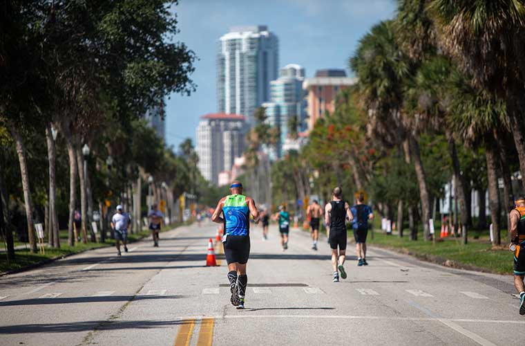 Athletes run through the streets of a city in a competition.