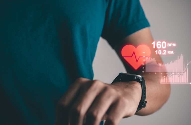 A man checks his smart watch, which displays his heart rate data.