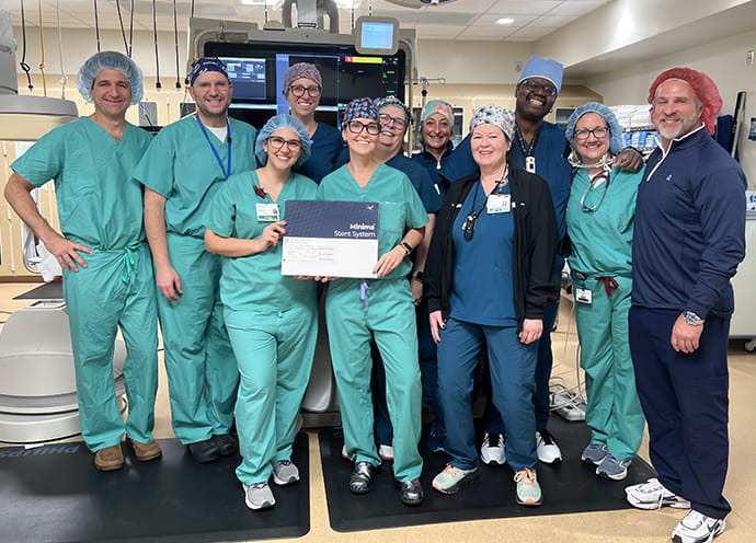 A group of people wearing scrubs standing together in an operating room.