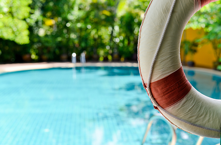 Lifebuoy hanging on a wooden beam at the pool