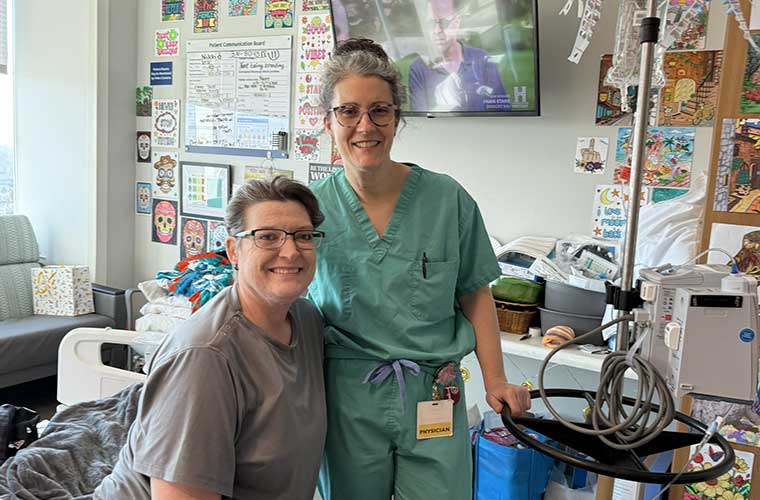 Nikki Reed, sitting, with Elizabeth Myers, DO, in the room that became  Nikki's home for nearly a year at St. Joseph's Hospital.