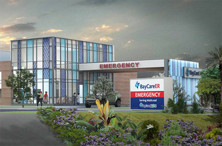 An artist's rendering depicts a building that is, in certain sections, two stories tall, with floor-to-ceiling windows of varying clarity and color patterns. An awning reaches toward the foreground, with signage on the awning displaying the word "EMERGENCY." A sign in front of the building includes the words, “BayCareER” and “Serving Adults and BayCare Kids.” A sunset sky and green foliage can be seen in the background and foreground, respectively.