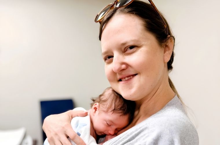 A mother holds her sleeping 1-month-old infant against her shoulder during a Baby Café session at Mease Countryside Hospital.