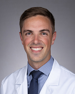 Travis Hotchkiss headshot in a lab coat