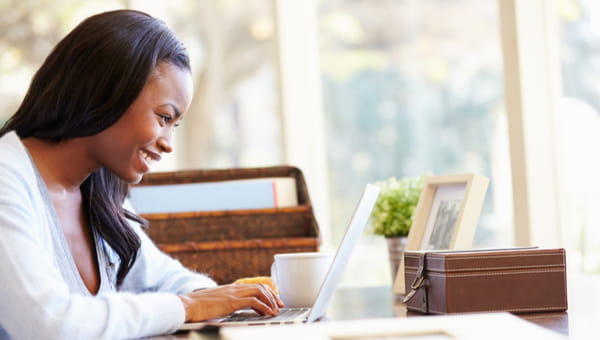 A young woman is typing on her laptop.