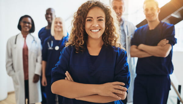 Female doctor standing in front of a group of doctors