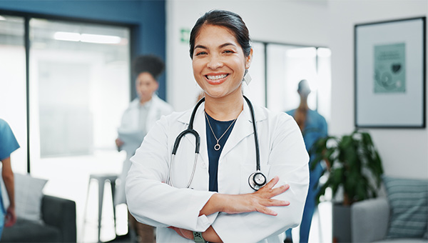 Smiling female doctor with arms her crossed.
