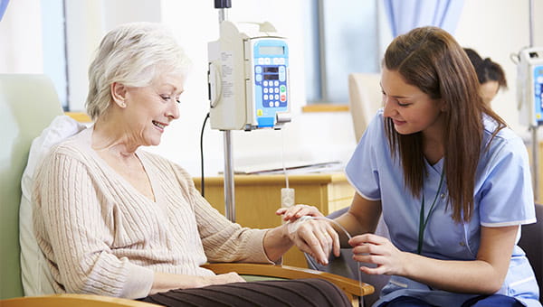 Lady sitting with a nurse who is working on her IV