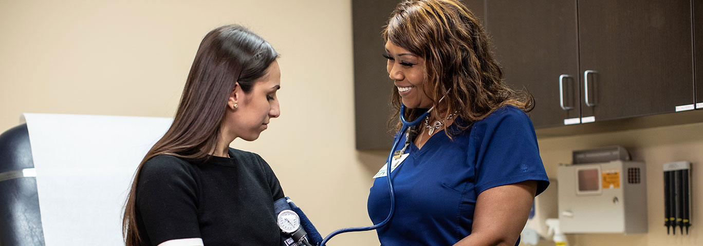 female baycare clinical checking the blood pressure of female patient