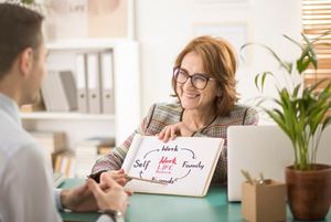 Smiling coach talking about work-life balance with a corporate employee