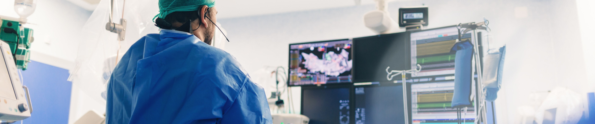 Surgeon examining a medical screen in an operating room.