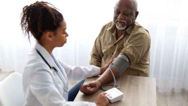 A doctor measures the blood pressure of a man, assessing his condition related to heart failure.