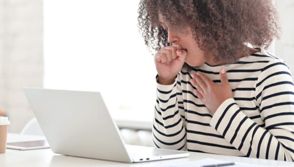 A woman uses an online symptom checker on her laptop.